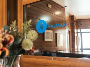 a mirror in a room with a vase of flowers at HOTEL VALMAR in Cuenca