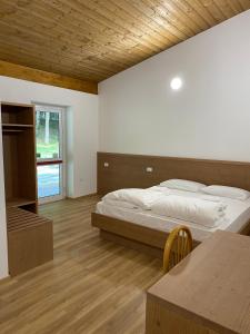 1 dormitorio con cama y techo de madera en Rifugio Pian dei Ciclamini, en Lusevera