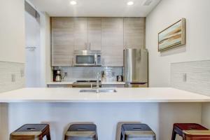 una cucina con lavandino e bancone con sgabelli di Parker's Collection Estate a Savannah