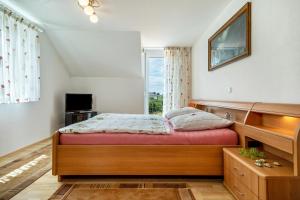 1 dormitorio con cama de madera y ventana en Storchennest, en Markdorf