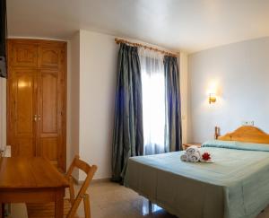 um quarto com uma cama, uma mesa e uma janela em HOTEL VALMAR em Cuenca