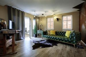 ein Wohnzimmer mit einem grünen Sofa und einem TV in der Unterkunft NeuWerk in Erfurt