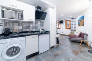 uma cozinha com uma máquina de lavar roupa e uma sala de estar em ESTUDIO 10 Junto a La Campana Alameda Setas em Sevilha