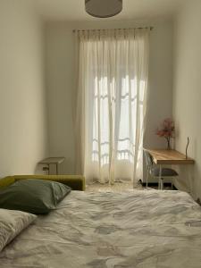 een slaapkamer met een bed en een raam met een bureau bij Cosy et splendide appartement ! in Nice
