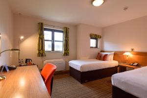 a hotel room with two beds and a table at Cranfield Management Development Centre in Cranfield