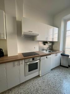 een keuken met witte kasten en een wastafel bij Cosy et splendide appartement ! in Nice