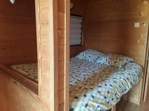 a bed in a wooden cabin with a mirror at Monts de flandre insolite in Berthen