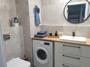 a bathroom with a washing machine and a mirror at STARA CEGIELNIA, Faktura VAT, bezkontaktowe zameldowanie in Poznań