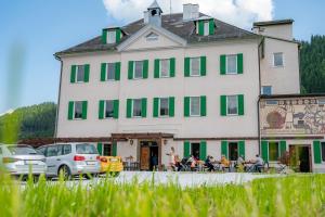 a large white building with people sitting outside of it at Lorettohof Hotel Garni in Gaal