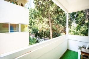 uma varanda vazia com uma grande janela e piso verde em One bedroom and a patio-Is all about the location! em Tel Aviv