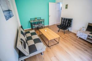uma sala de estar com um sofá, uma mesa e cadeiras em One bedroom and a patio-Is all about the location! em Tel Aviv
