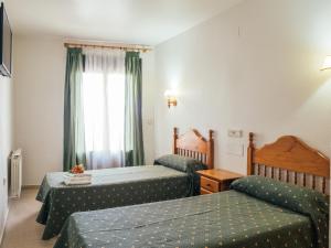 a hotel room with two beds and a window at HOTEL VALMAR in Cuenca
