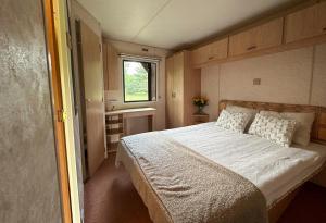 a bedroom with a large bed and a window at Domek holenderski in Rydzewo