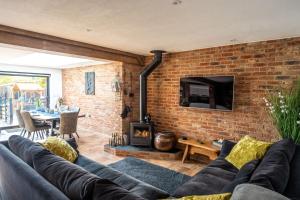 a living room with a couch and a brick wall at At Last in West Beckham