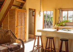 uma cozinha com um balcão e bancos num quarto em Singila Ocean Lodge em Inhambane