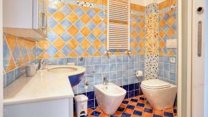een blauw betegelde badkamer met een toilet en een wastafel bij Italianway - Paisiello 4 B in Milaan