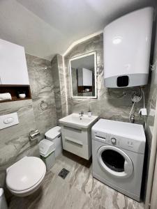 a bathroom with a sink and a washing machine at Apartments Porat in Sveti Stefan