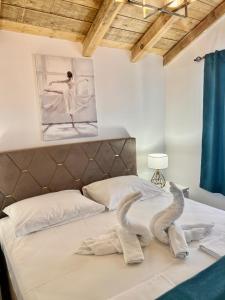 two stuffed animals on a bed in a bedroom at Apartments Porat in Sveti Stefan