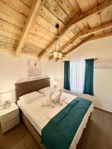 a bedroom with a large bed in a room with wooden ceilings at Apartments Porat in Sveti Stefan