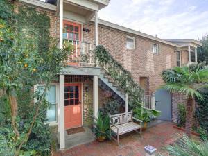una casa de ladrillo con una escalera y un banco en Crawford Carriage House, en Savannah