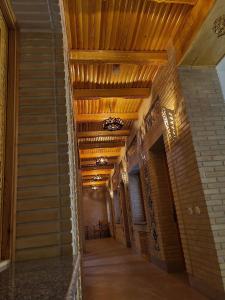 un couloir vide dans un bâtiment doté d'un plafond en bois dans l'établissement Hanifa Boutique Hotel, à Samarcande