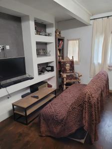 um quarto com uma cama, uma televisão e uma cadeira em Le toit du monde em Ceyreste