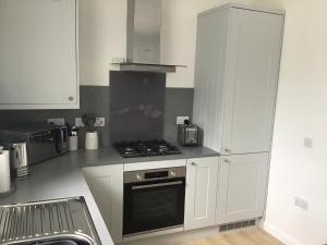 a kitchen with white cabinets and a stove top oven at 5a Plantation Road in Stornoway