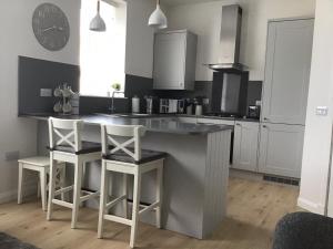a kitchen with a counter and stools in it at 5a Plantation Road in Stornoway