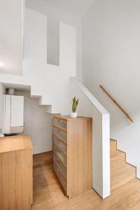 a room with a staircase and a dresser with a plant on it at Luxury 2bed Apartment in Jesmond with Parking! in Jesmond