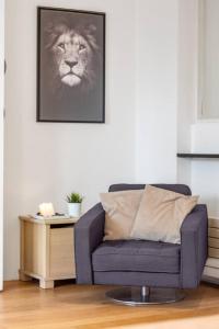 uma sala de estar com um sofá azul e uma fotografia de um leão em Luxury 2bed Apartment in Jesmond with Parking! em Jesmond