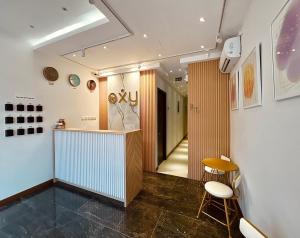 a hallway with a counter and chairs in a room at Oxy suites 2-02 at Shop House Meisterstadt Pollux Habibie in Batam Center