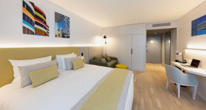 Cette chambre comprend un grand lit et un bureau. dans l'établissement Crowne Plaza - Marseille Le Dôme, à Marseille