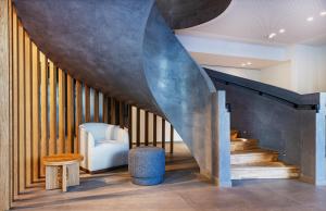 a living room with a staircase with a blue chair at Crowne Plaza - Marseille Le Dôme in Marseille