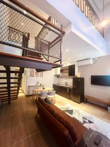 a living room with a couch and a staircase at Oxy suites 2-02 at Shop House Meisterstadt Pollux Habibie in Batam Center