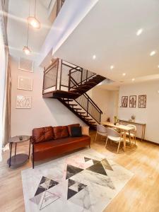 - un salon avec un canapé et un escalier en colimaçon dans l'établissement Oxy suites 2-02 at Shop House Meisterstadt Pollux Habibie, à Batam Center