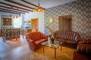 a living room with two leather couches and a table at Lorettohof Hotel Garni in Gaal