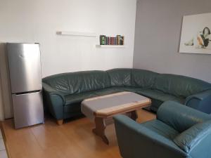a living room with a green couch and a refrigerator at Gästewohnung in Pirmasens