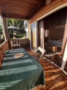 eine abgeschirmte Veranda mit einem Tisch und einem Bett in der Unterkunft La Kaz Ouale in Saint-Leu