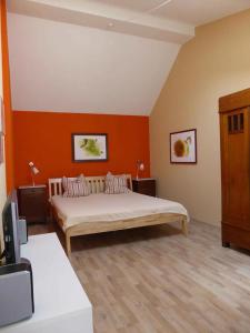 um quarto com uma cama num quarto com paredes cor-de-laranja em Lincoln-Loft Weimar em Weimar