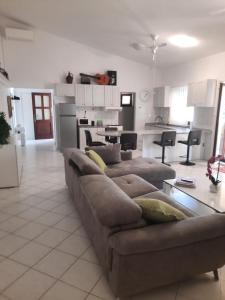 a living room with a couch and a kitchen at Modern Villa with Garden & Terrace, 13 min to Pula Arena in Pula