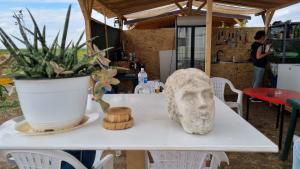 una mesa con una estatua en la cabeza. en Makeeda Camping, en Vama Veche