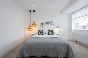 a white bedroom with a bed and a window at Scandi Inspired Home In Eccles in Manchester