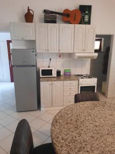 a kitchen with white cabinets and a table and a guitar at Modern Villa with Garden & Terrace, 13 min to Pula Arena in Pula +72 photos