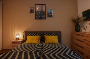 a bedroom with a bed and two yellow pillows at Danube Family Premium Apartment in Budapest