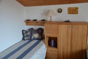 1 dormitorio con 1 cama y armario de madera en AlpenGlück – **** Ferienwohnung, en Siegsdorf