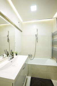 a white bathroom with a tub and a sink at Danube Family Premium Apartment in Budapest