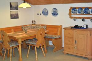 comedor con mesa de madera y sillas en AlpenGlück – **** Ferienwohnung, en Siegsdorf