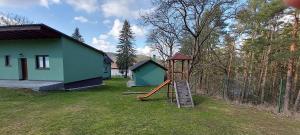 einen Spielplatz mit Rutsche vor einem Haus in der Unterkunft Apartmán Slapy, slapská přehrada - Nová Živohošť in Křečovice