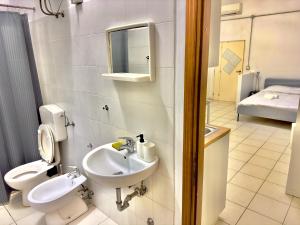 een badkamer met een wastafel, een toilet en een spiegel bij “Il Casale Nel Bosco…Al Mare” in Lido di Savio