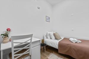 una camera da letto bianca con un letto e una scrivania di Apartman Žužić a Novigrad Istria
